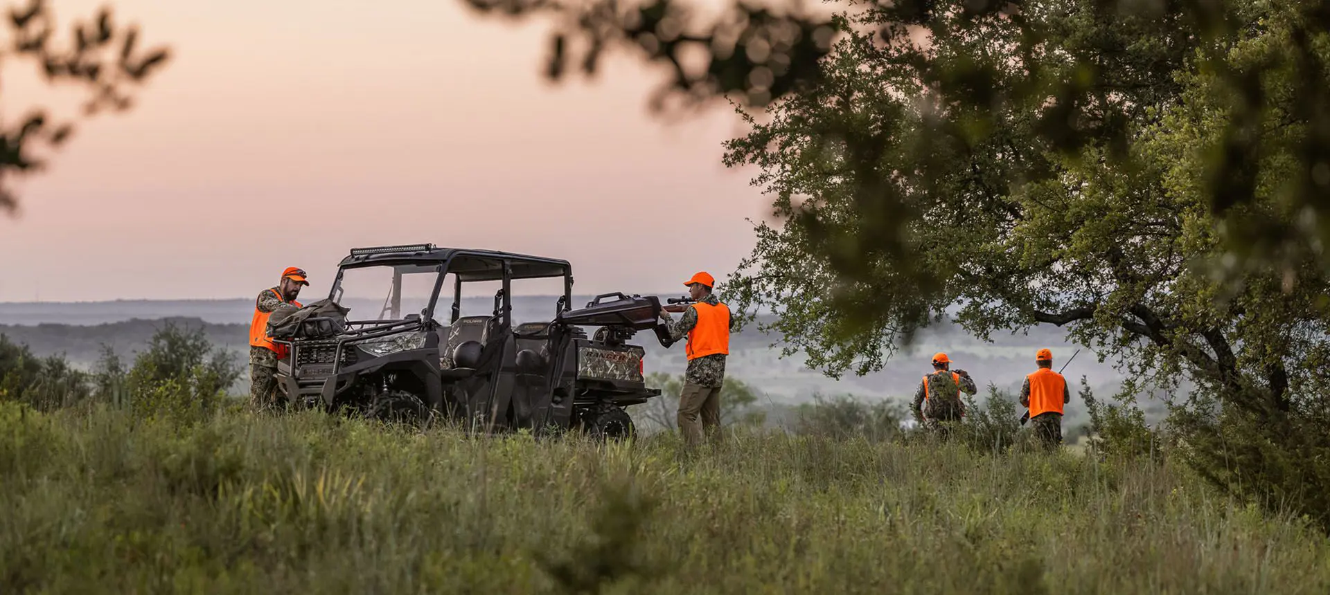 hunters unloading gear from the cargo box of their polaris ranger crew sp 570