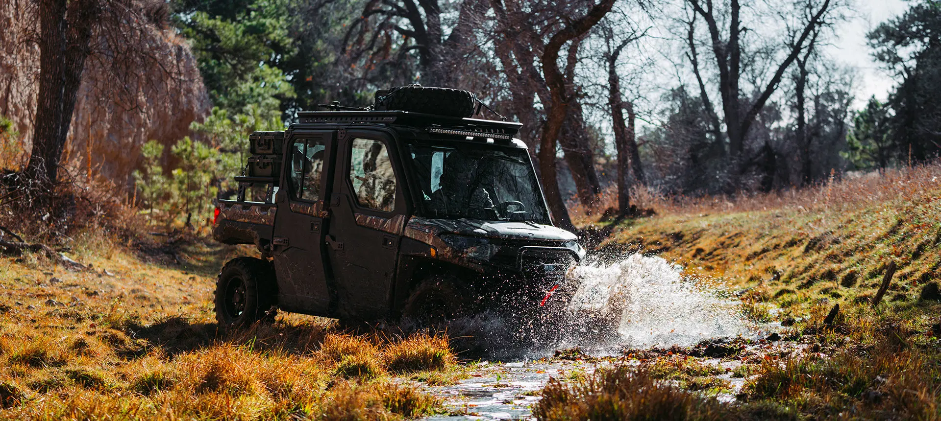 a polaris ranger crew xp 1000 northstar big game edition utv driving through a stream