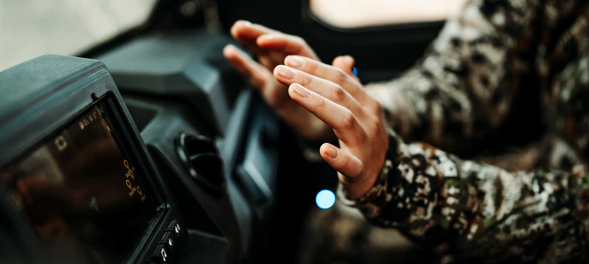 person warming their hands on the heater in the cab of a polaris ranger crew xp 1000 northstar big game edition utv
