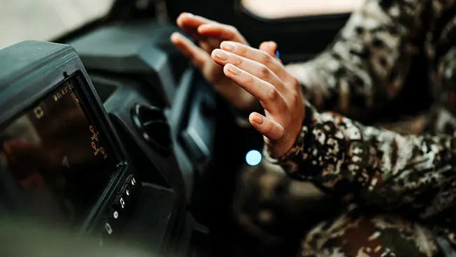 person warming their hands on the heater in the cab of a polaris ranger crew xp 1000 northstar big game edition utv