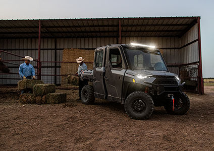 2 people loading hay into cargo box on their Ranger Crew XP 1000 NorthStar Edition