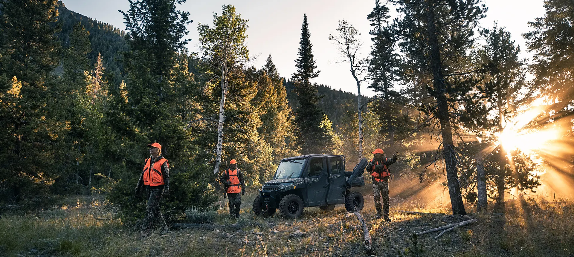 3 chasseurs qui sortent de leur Ranger Crew XP 1000 édition NorthStar dans la forêt