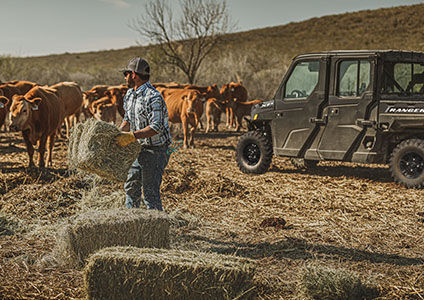 A man loading hay on his Ranger Crew XP 1000