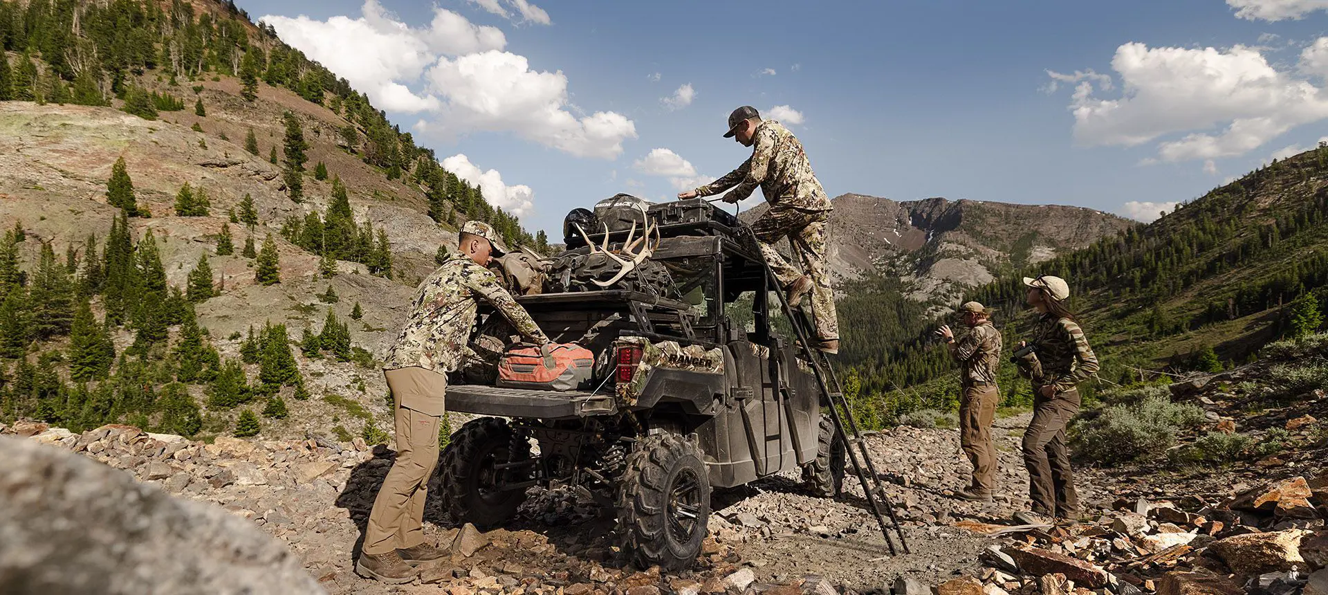cazadores descargando equipo de la caja de carga y portaequipajes de techo rhino rack en su ranger crew xp 1000