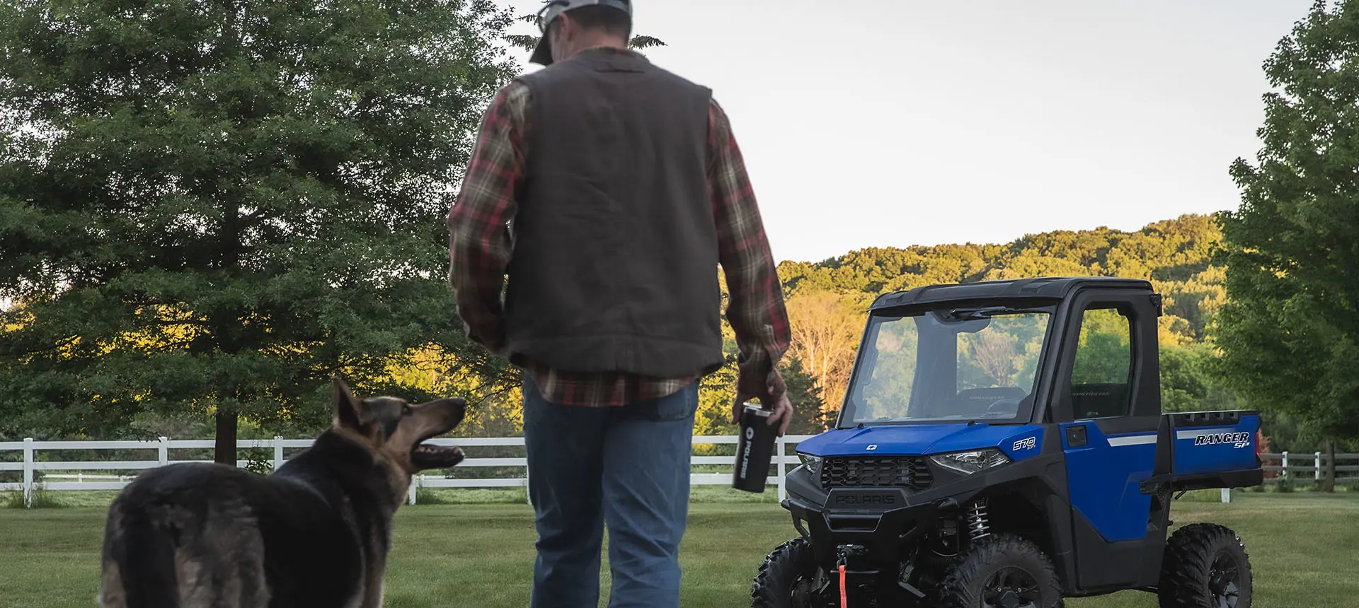 Man and dog walking to Ranger SP 570 on a farm
