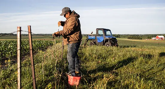 Farmer mending fence with tools from his RANGER SP 570 Northstar edition