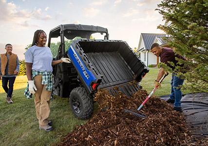 Family using the dump box on a Ranger SP 570 to spread mulch