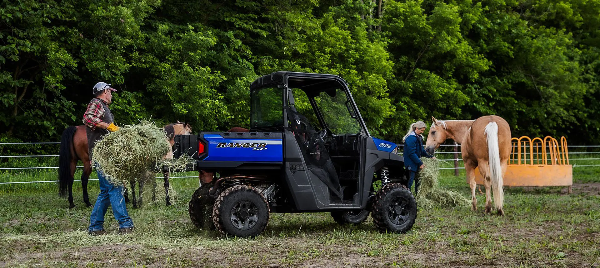 Man unloading a square bale from the cargo box of his RANGER SP 570