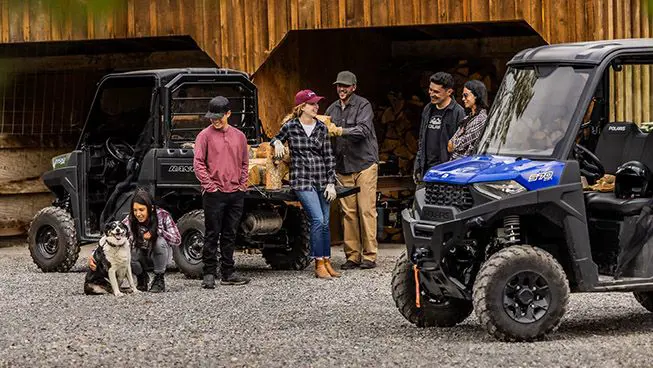 Group of friends relaxing near their RANGER SP 570 utvs
