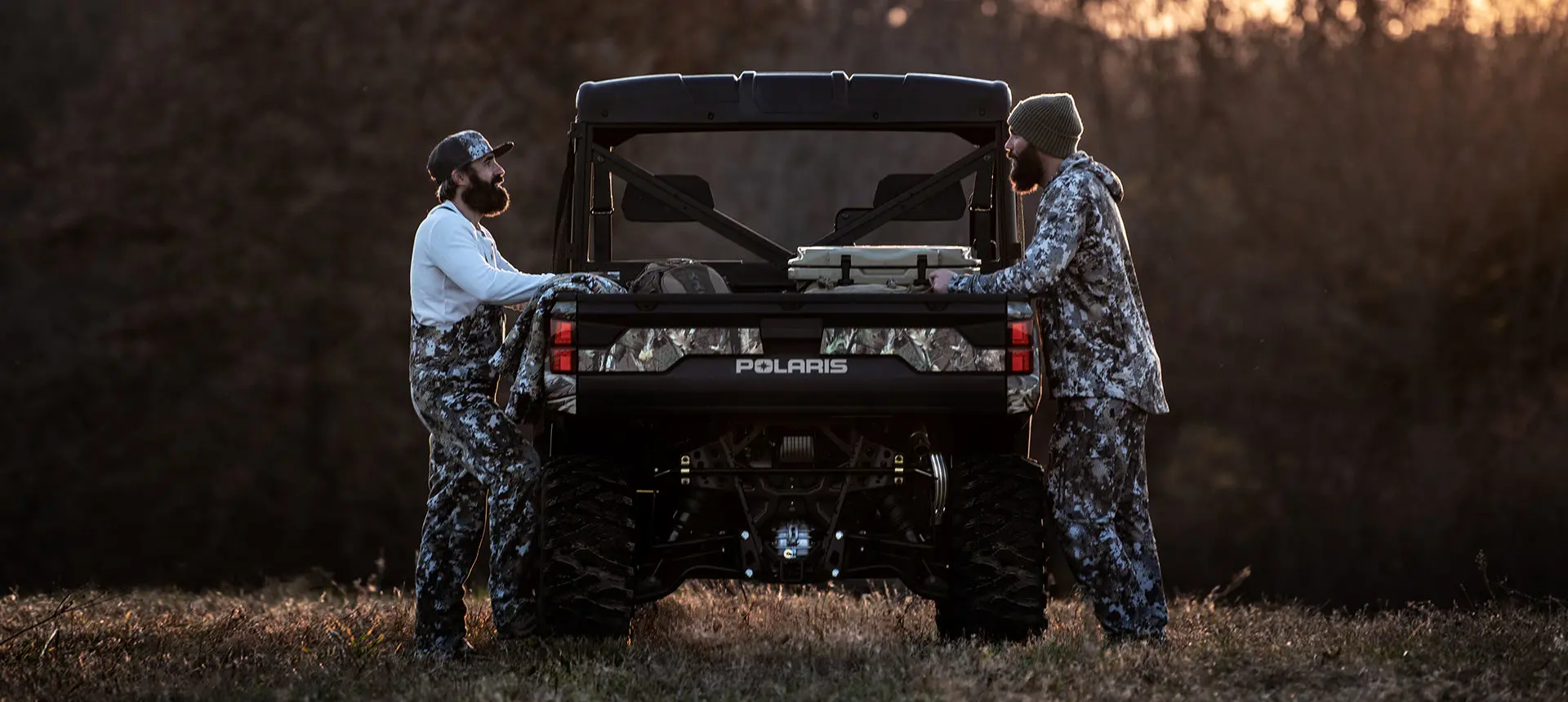 rear view of a polaris ranger xp 1000 big game edition utv with 2 hunters nearby