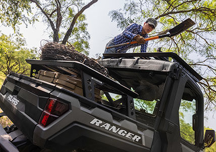 Hombre guardando su pala en el sistema de portaequipajes de plataforma Rhino-Rack de su Ranger XP 1000 Northstar Edition