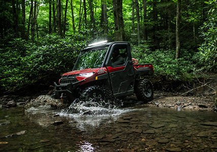 RANGER XP 1000 NorthStar Edition atravesando un charco en un bosque
