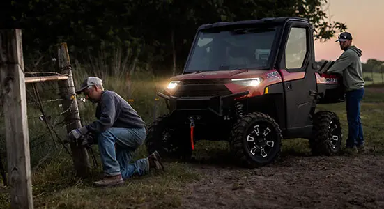 Hombre arreglando una cerca con herramientas de la caja de carga de su Ranger XP 1000 NorthStar Edition