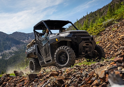 Ranger XP 1000 grimpant une colline rocheuse