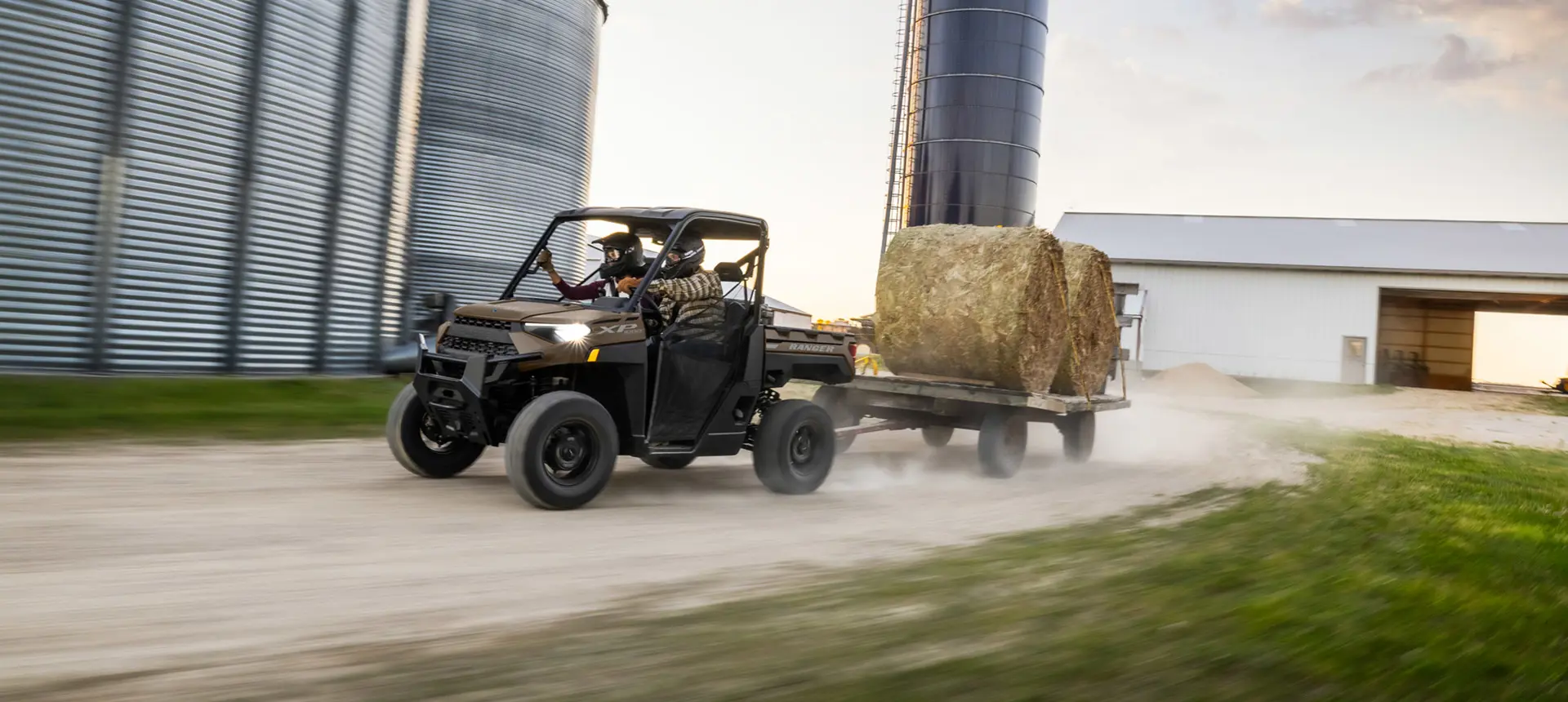 VUTT Polaris RANGER XP 1000 tirant une remorque avec des balles de foin sur une ferme