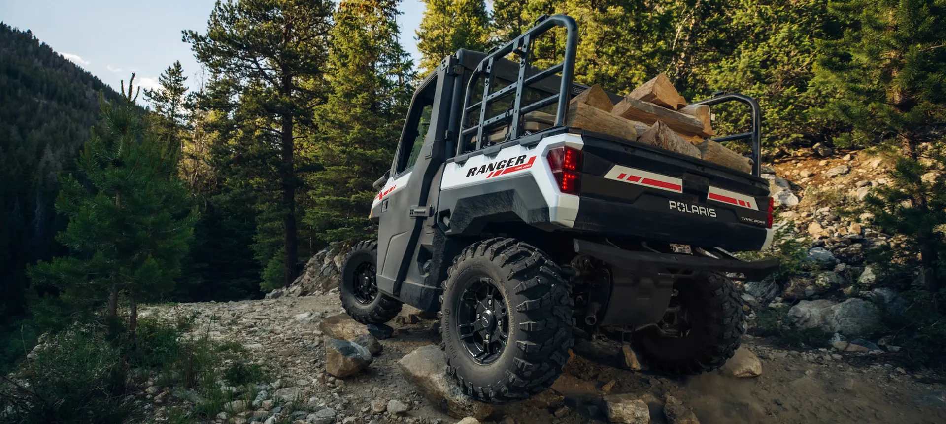 ranger xp 1000 northstar edition trail boss utv carrying wood over rocky terrain
