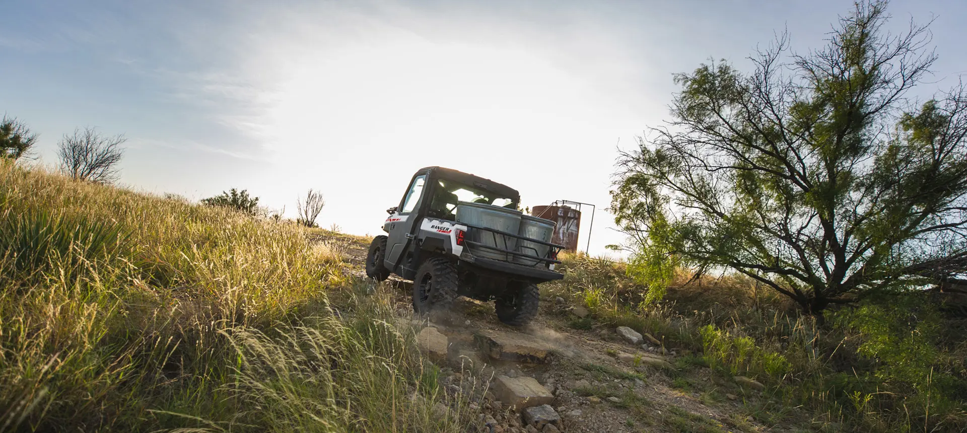 ranger xp 1000 northstar edition trail boss utv hauling water tubs on a farm