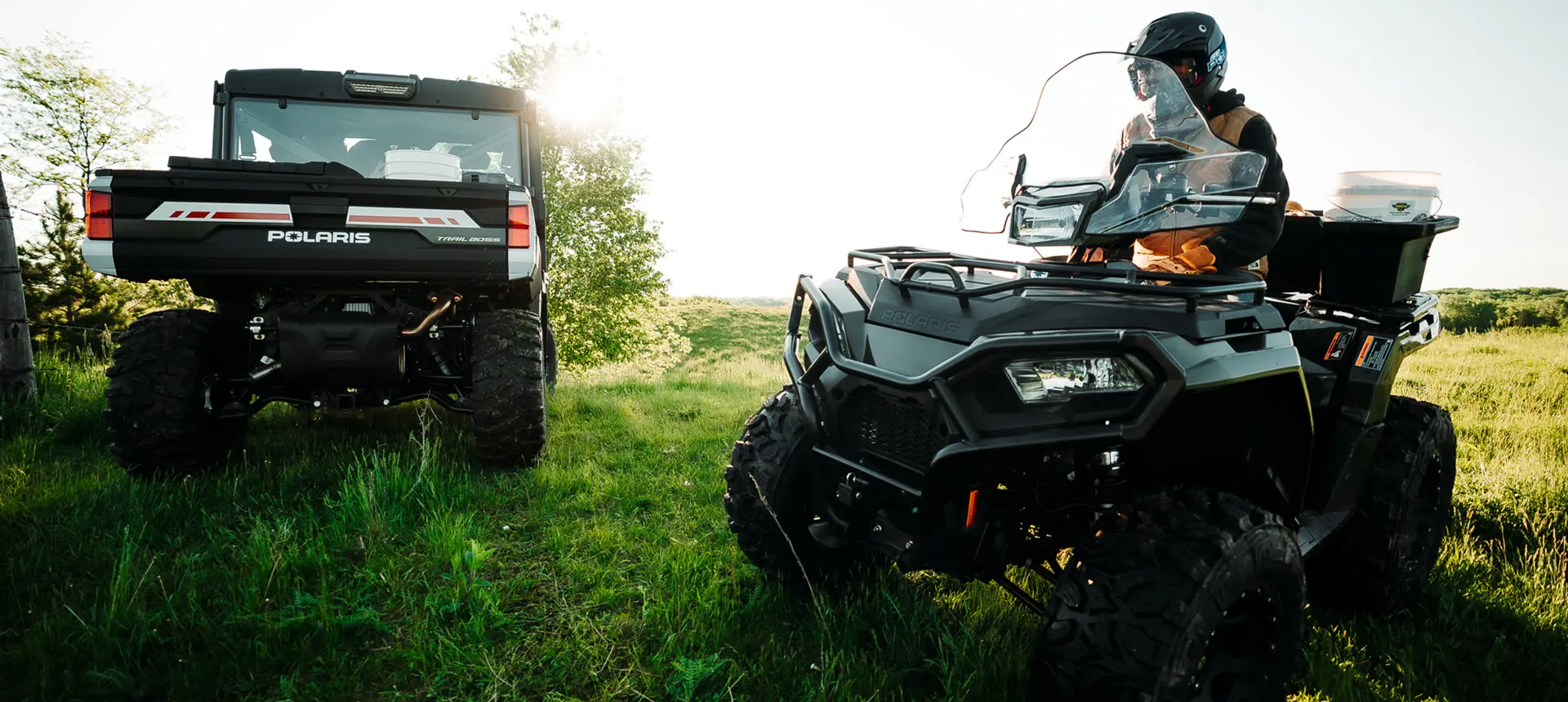 polaris sportsman atv parked near a ranger xp 1000 northstar edition trail boss utv