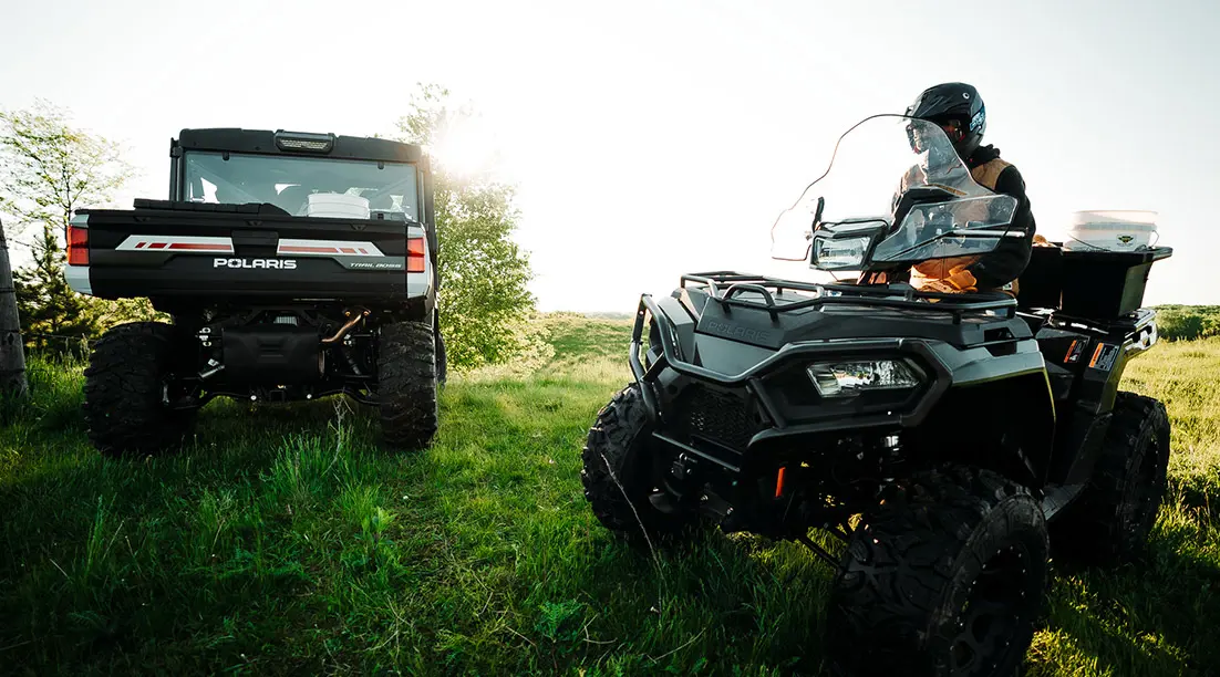 polaris sportsman atv parked near a ranger xp 1000 northstar edition trail boss utv