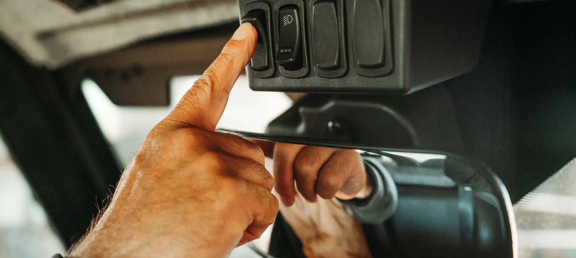 person hitting switches in the interior of their ranger xp 1000 northstar edition trail boss utv