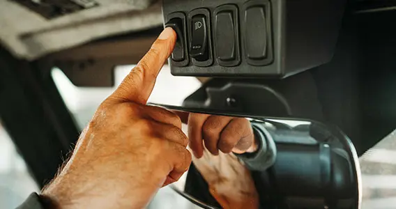 person hitting switches in the interior of their ranger xp 1000 northstar edition trail boss utv