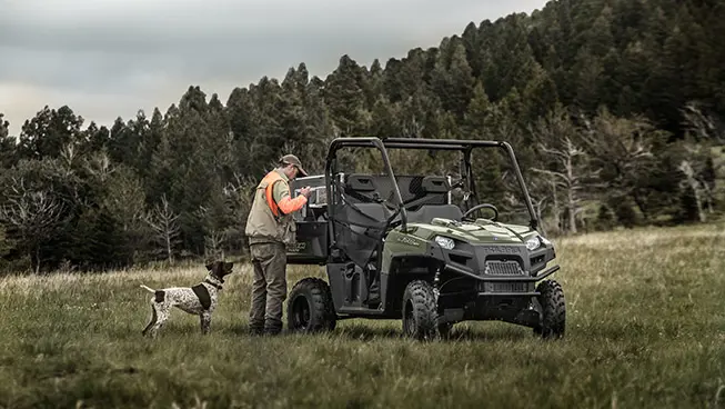 hunter unloading gear from the cargo box on his ranger 570 full-size utv