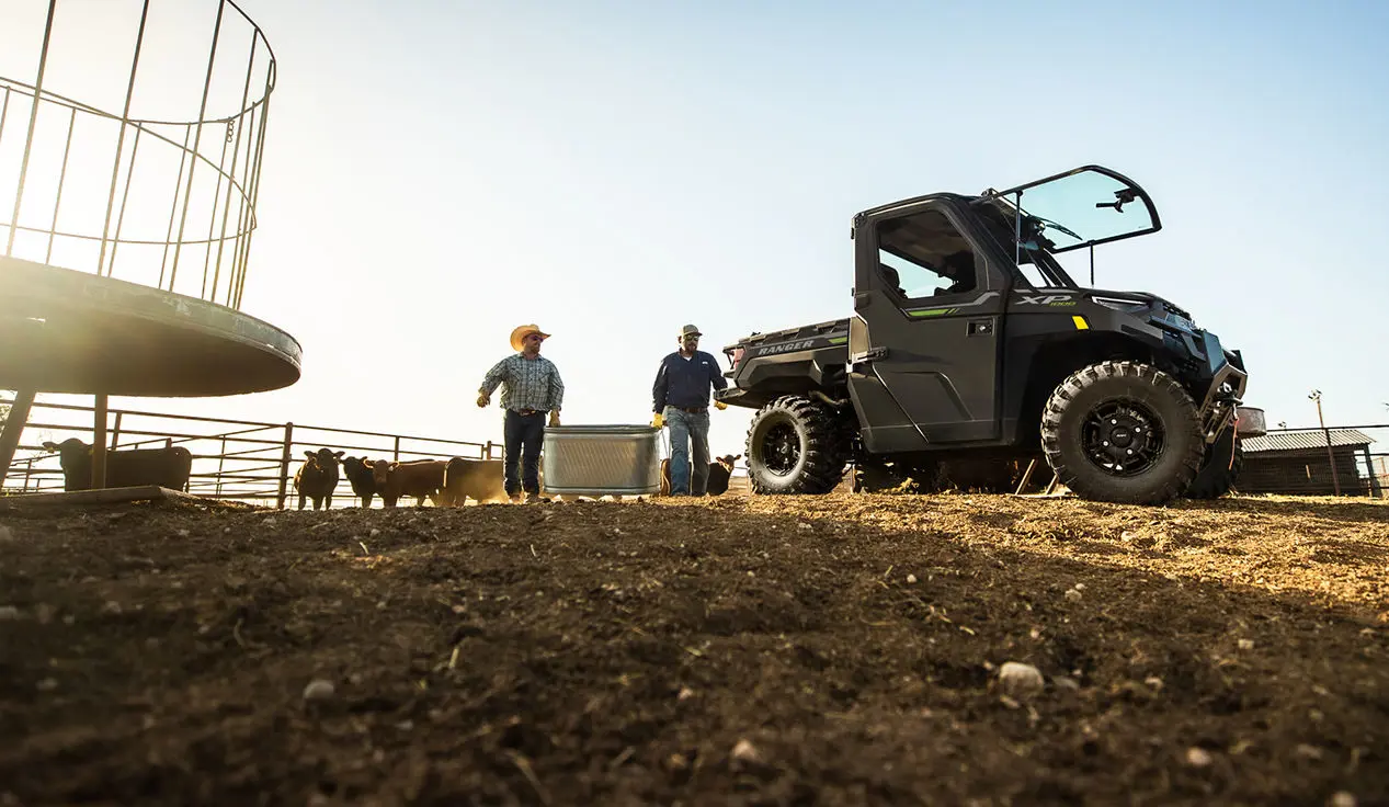 farmers walking with a feed bin towards their ranger xp 1000 northstar edition utv