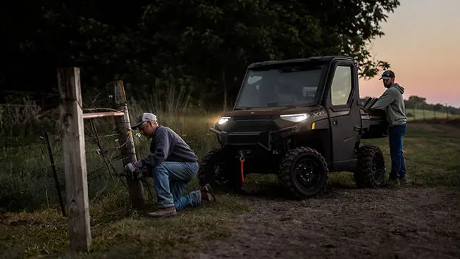 farmers fixing fence and grabbing gear from the cargo box of their ranger xp 1000 northstar edition utv