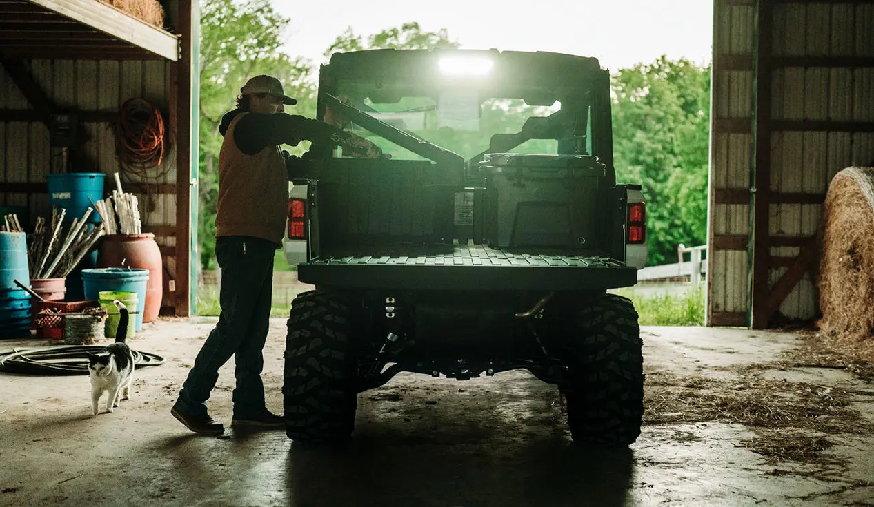 farmer grabbing gear from the cargo box of their ranger xp 1000 northstar edition trail boss utv