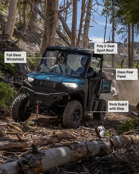 Parabrisas de vidrio completo, techo deportivo de polietileno para vehículo de dos asientos, panel trasero de vidrio y protector de rocas con accesorios escalonados de la colección Trail instalados en un UTV Polaris RANGER SP 570 de 2025.