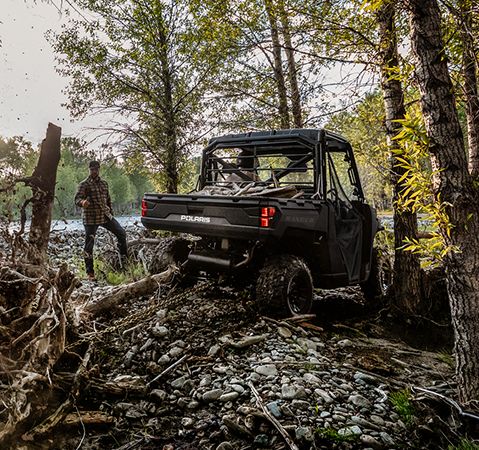 2025 Polaris RANGER 1000 UTV pulling a stump out with a chain attached to the receiver hitch. 