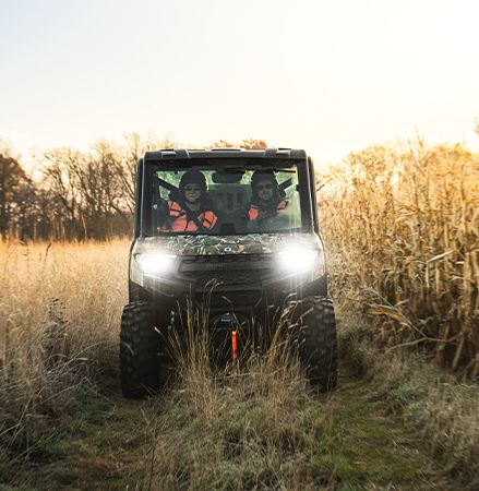 Front view of a 2025 Polaris RANGER XP 1000 NorthStar Edition UTV with LED headlights illuminated.