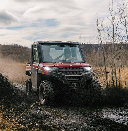 2025 Polaris RANGER XP 1000 NorthStar Edition UTV powering through a muddy trail with ease.