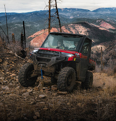 The durable cabbed 2026 Polaris RANGER XP 1000 NorthStar Edition UTV powering over rocky terrain with ease.