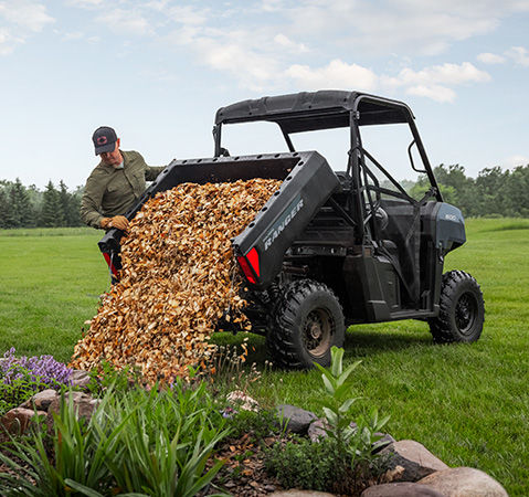 Un hombre usando la caja de descarga de un UTV Polaris RANGER 500 2026.