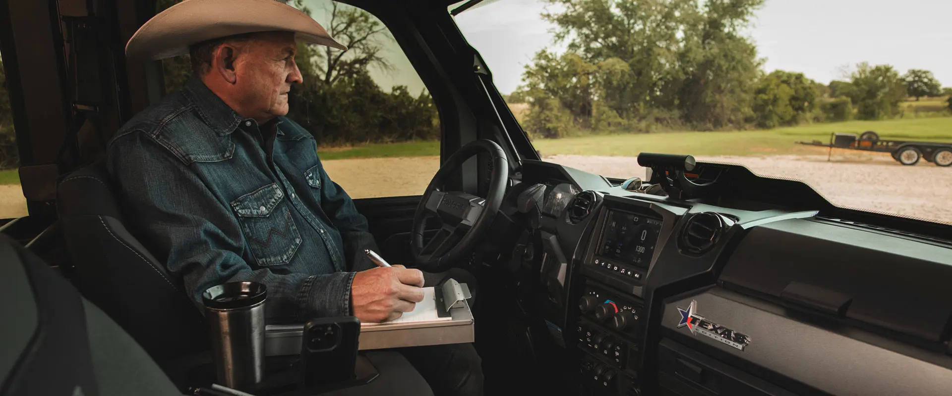 A rancher taking notes inside a 2026 Polaris RANGER CREW XD 1500 NorthStar Texas Edition extreme duty UTV.