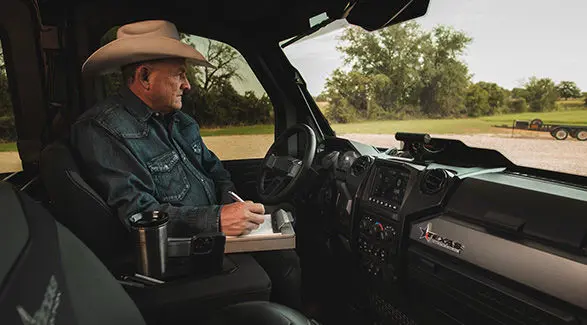 A rancher taking notes inside a 2026 Polaris RANGER CREW XD 1500 NorthStar Texas Edition extreme duty UTV.