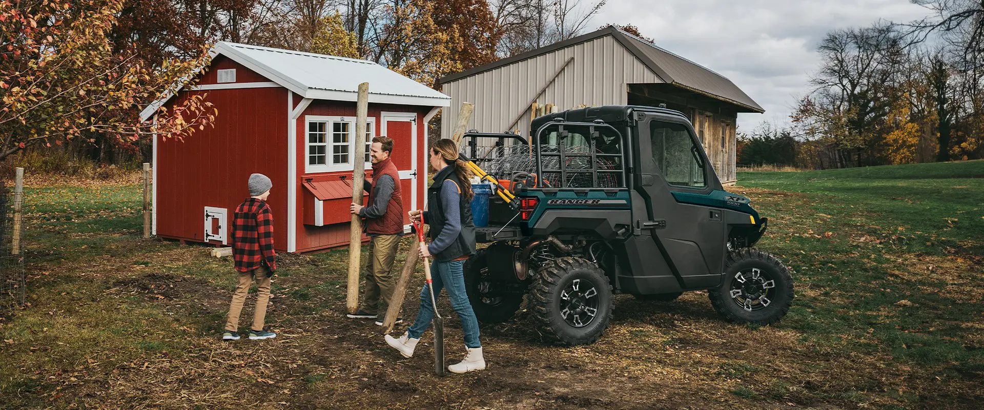 A family doing yardwork with the assistance of their 2026 Polaris RANGER XP 1000 NorthStar Edition utility vehicle.
