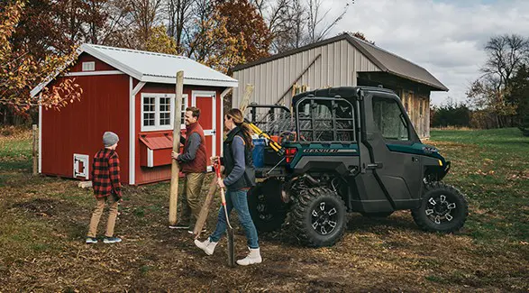 A family doing yardwork with the assistance of their 2026 Polaris RANGER XP 1000 NorthStar Edition utility vehicle.