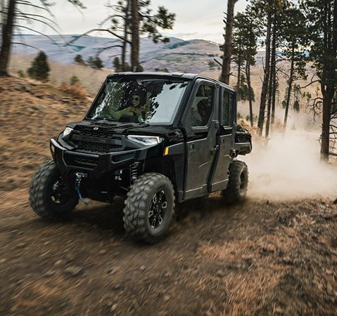 4 riders enjoying the air conditioning inside the cab of a 2026 Polaris RANGER CREW XP 1000 NorthStar Texas Edition UTV.