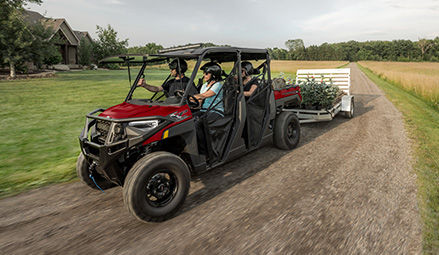 A 2026 Polaris RANGER CREW XP 1000 UTV pulling a trailer while the driver showcases the upgraded electronic power steering.