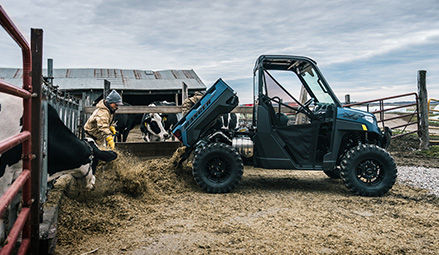 A farmer using the gas-assist dump box on a 2026 Polaris RANGER XP 1000 UTV.