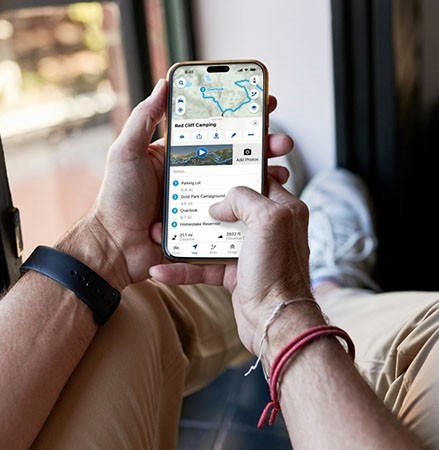 A person using the RIDE COMMAND app to plan a new ride.