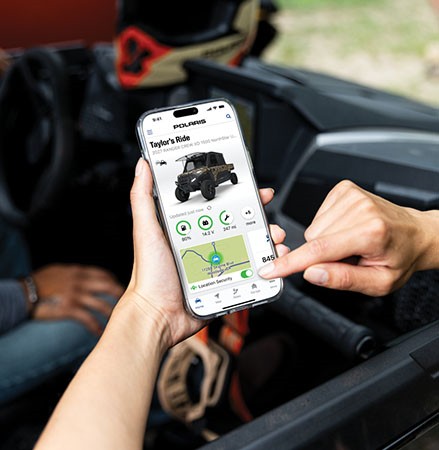A person using RIDE COMMAND+ on their smartphone to track their vehicle's health.