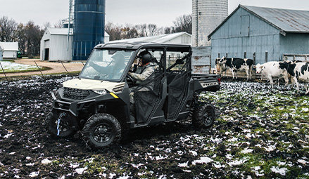 2 people leaving the cab of a 2027 Polaris RANGER 1000 CAB UTV.