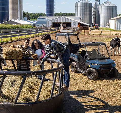 A kid helping with farm chores using his 2027 Polaris RANGER 150 EFI youth UTV.