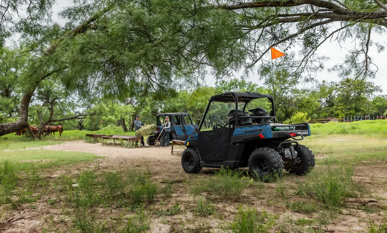 2 kids driving around the farm in their 2027 Polaris RANGER 150 EFI youth UTV.