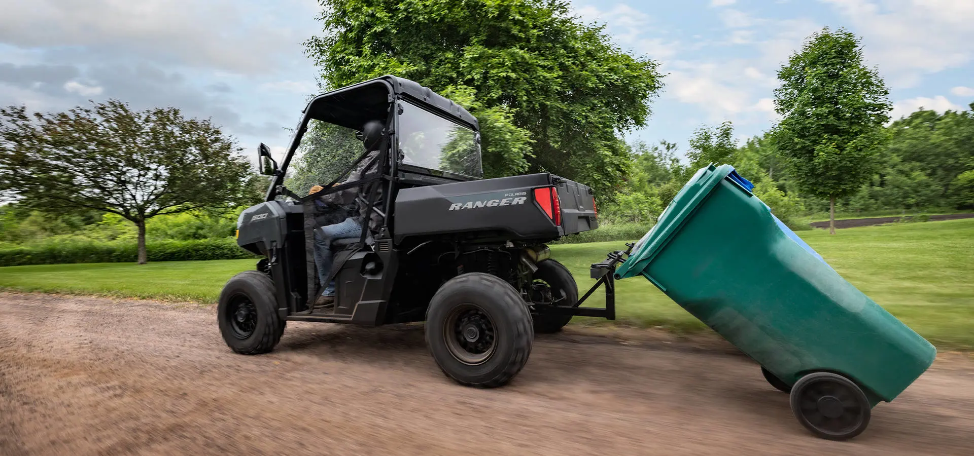 A 2027 Polaris RANGER 500 UTV pulling a trashcan home.