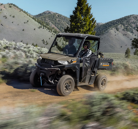2 riders in a 2027 Polaris RANGER 600 UTV enjoying a smooth ride down a trail.