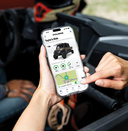 Person using the RIDE COMMAND Plus app on their smartphone.